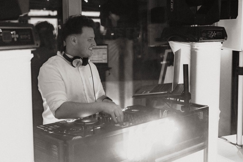 Alex am DJ-Pult, professionelles Setup mit Lichtshow für Hochzeiten und Events